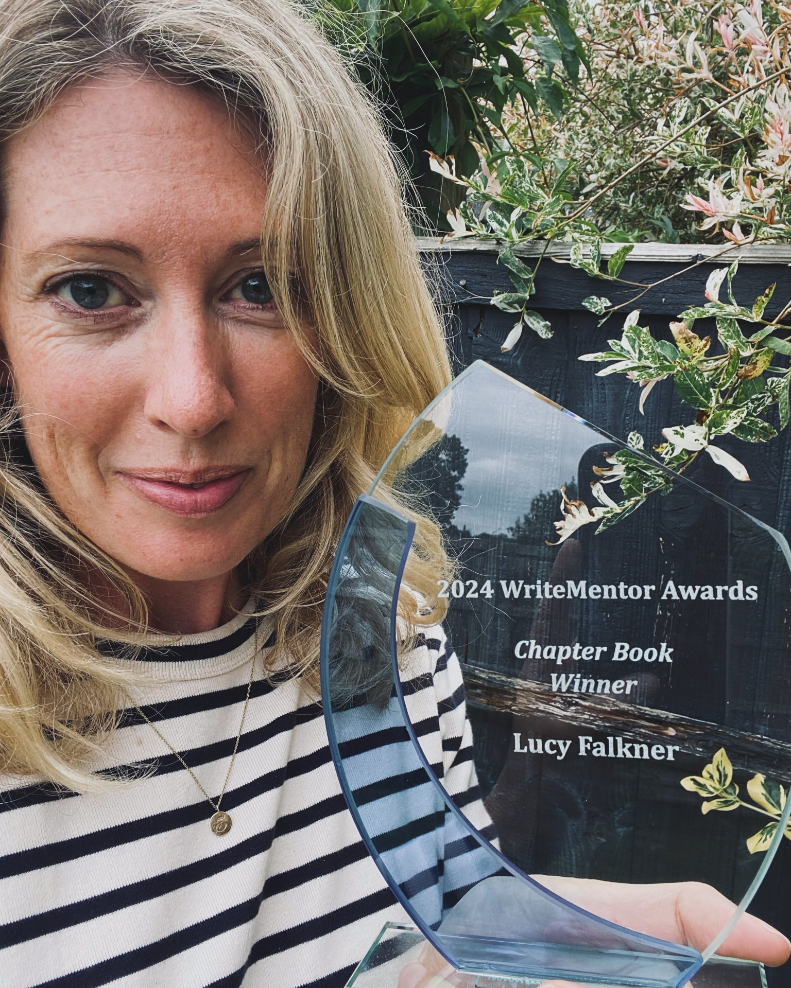 Lucy Falkner holding her 2024 WriteMentor Awards Chapter Book Winner trophy